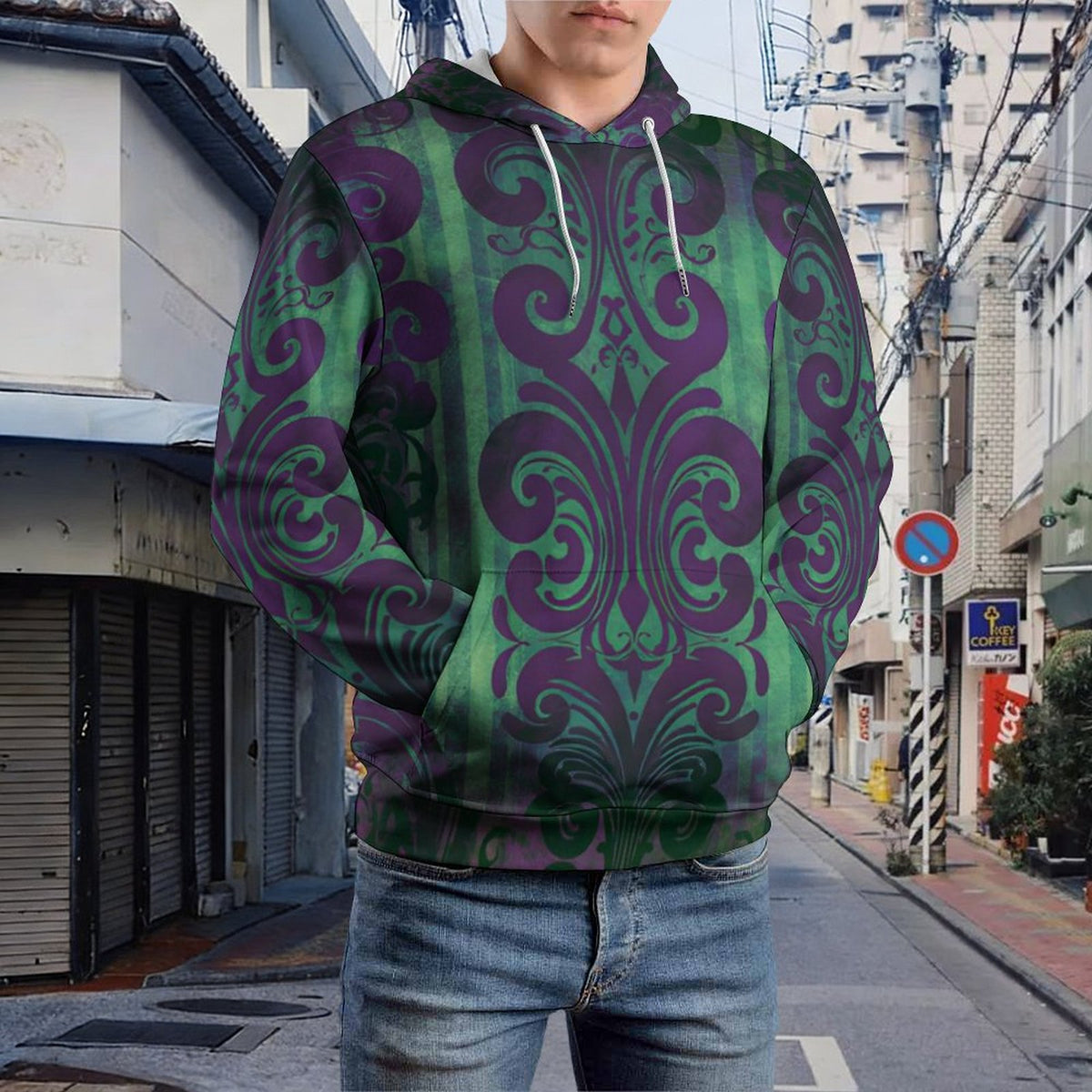 A person wearing a green and purple damask-patterned hoodie, standing on a city street.