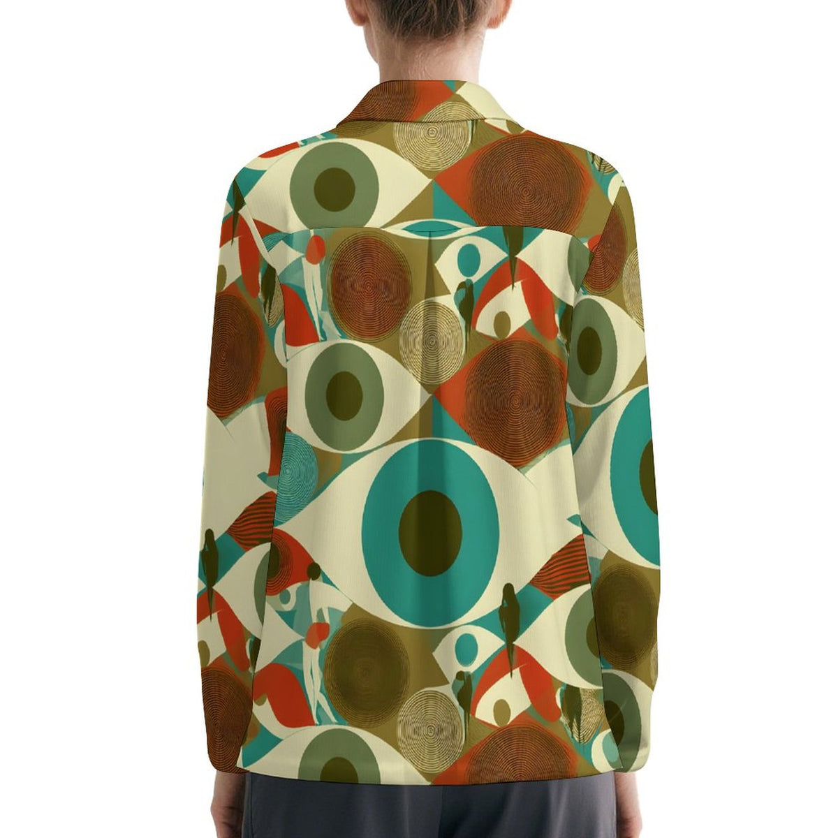 A person shown from the back wearing a long-sleeve collared blazer with a bold mid-century modern abstract print featuring large eyes, circles, and geometric shapes in teal, brown, rust red, olive green, and cream on a white background.
