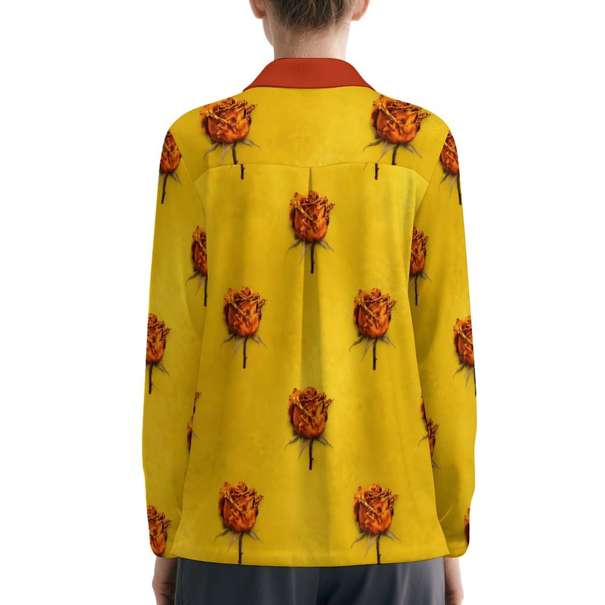 A person viewed from the back wearing a bright yellow long-sleeve shirt with an allover print of orange-brown roses and a contrasting red collar, against a plain white background.